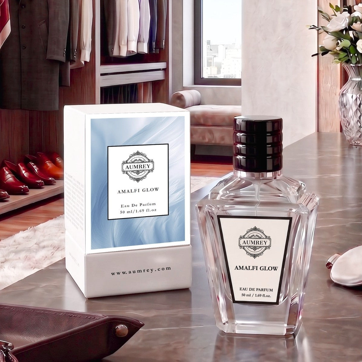 A bottle of Ambey Amalef Glow Eau de Parfum next to its white and light blue packaging box, displayed on a polished marble countertop in a luxury dressing room setting.