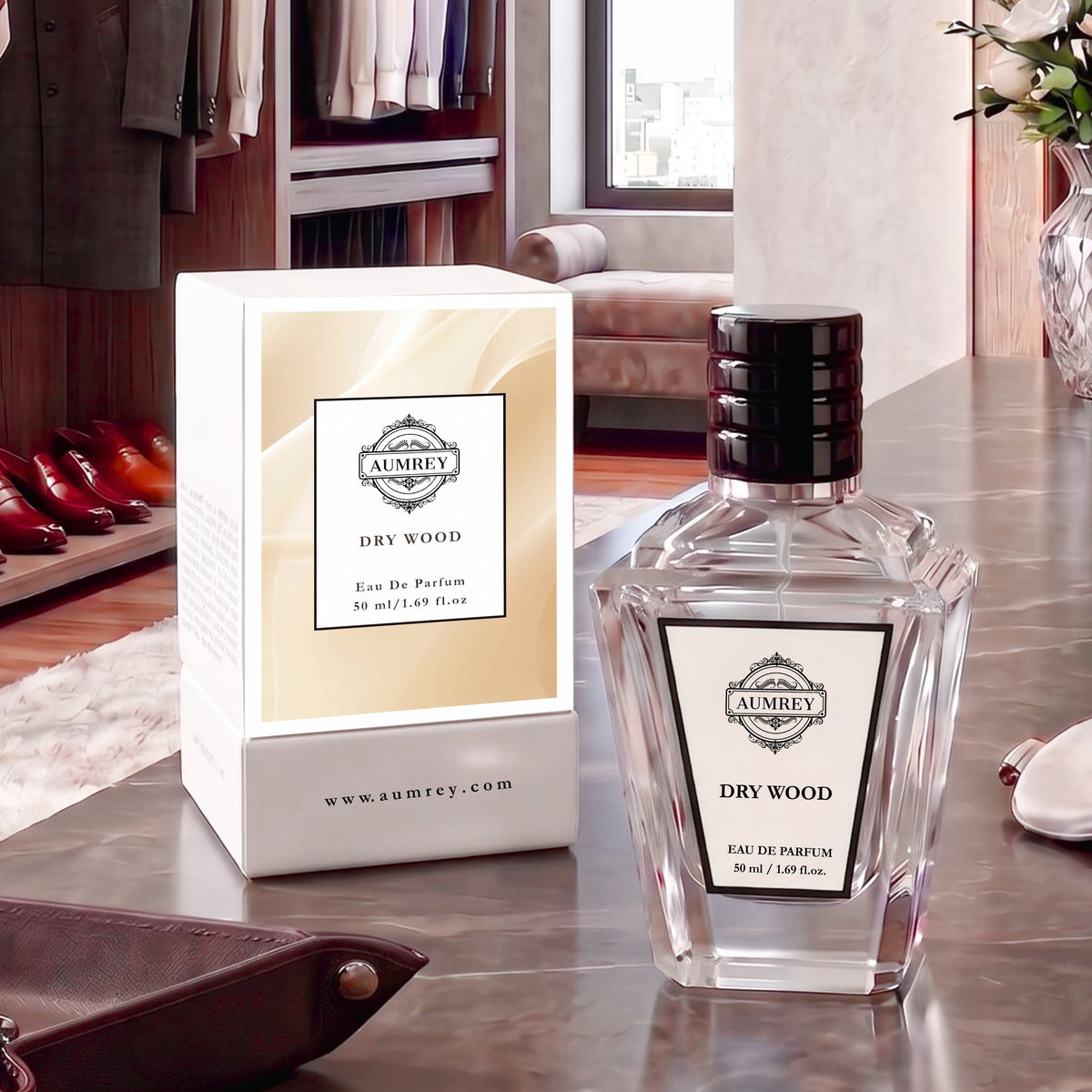 A clear glass perfume bottle labeled AUMNEY DRY WOOD Eau De Parfum next to its white and beige box, set on a polished metallic table in a stylish, modern room.