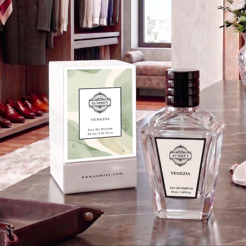 A bottle of Aumey Venezia Eau De Parfum next to its white and light green box, displayed on a polished marble countertop in a luxury dressing room setting.